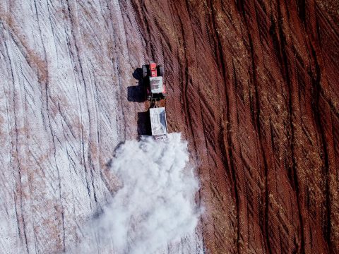 máquina agrícola fazendo a calagem do solo em área de soja.