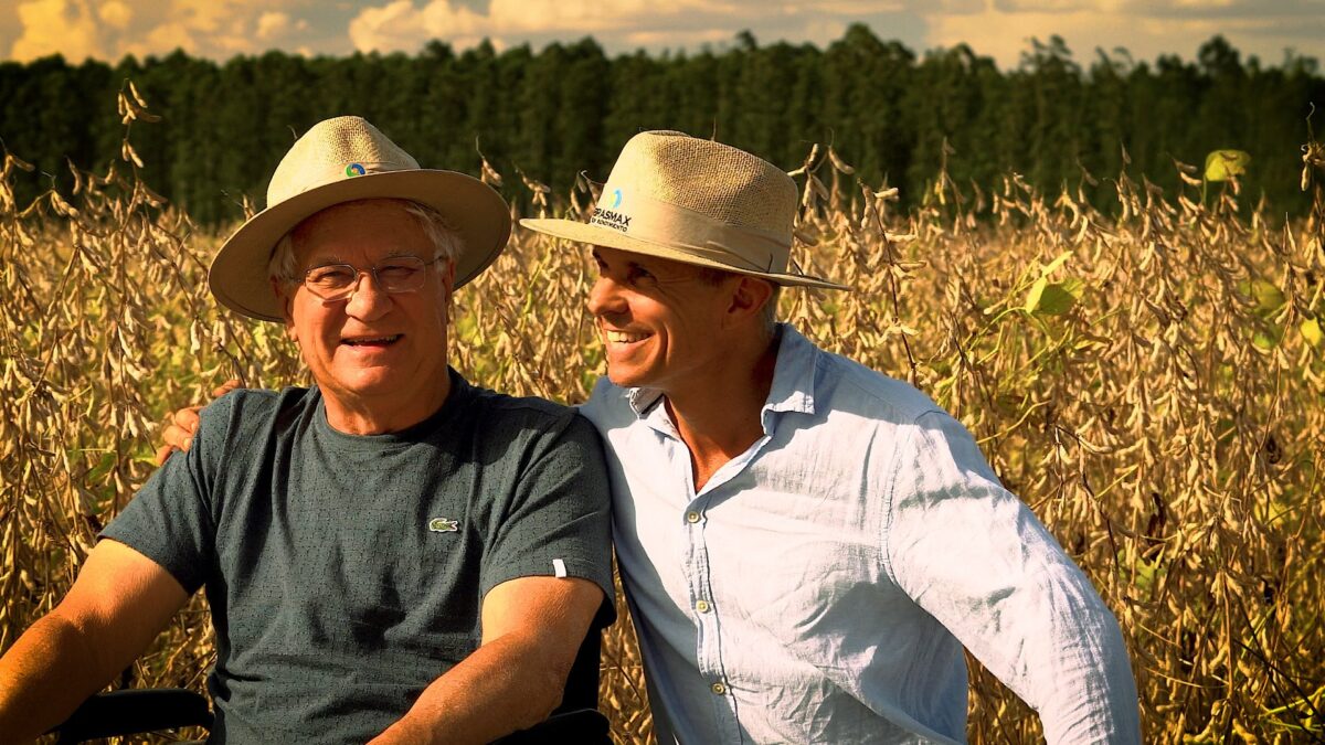 Pai e filho em lavoura de soja, projetando a sucessão rural.