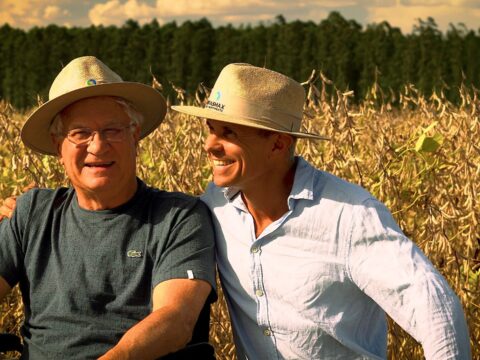 Pai e filho em lavoura de soja, projetando a sucessão rural.